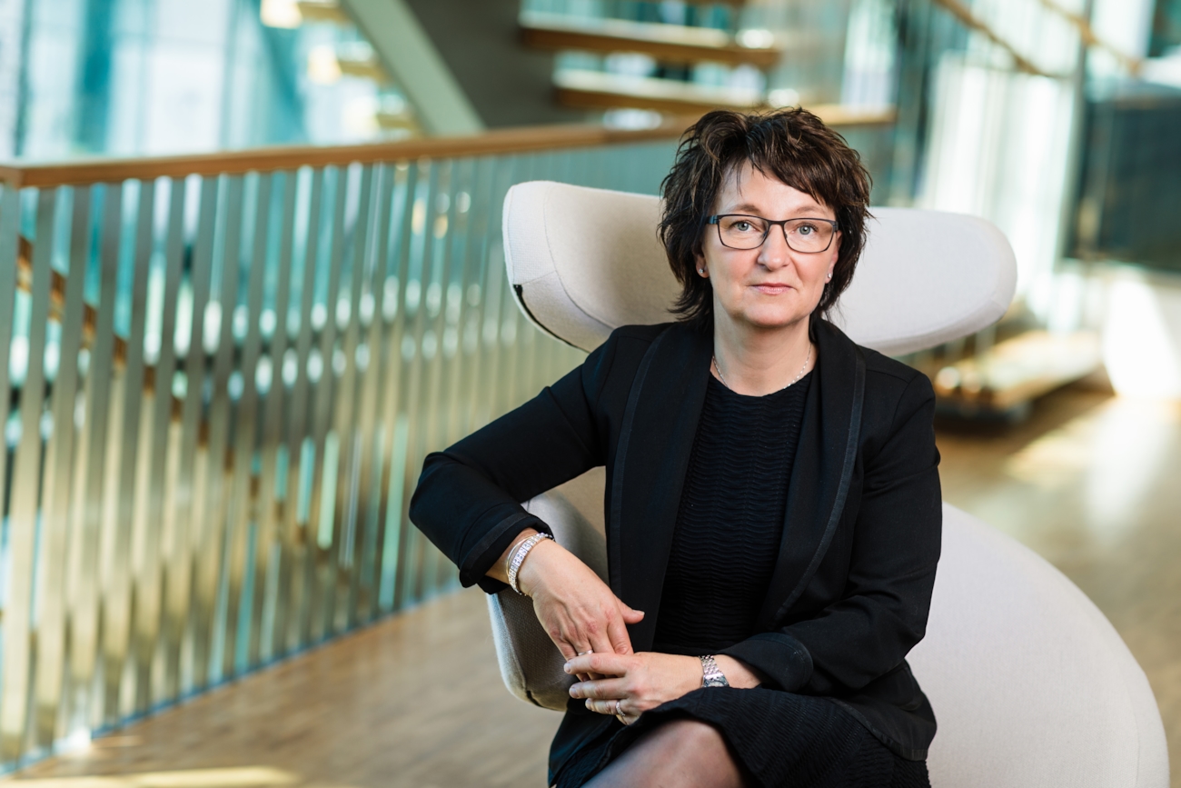 Inger-Lise M. Nøstvik sittende på en stol med trappeoppgang i bakgrunnen