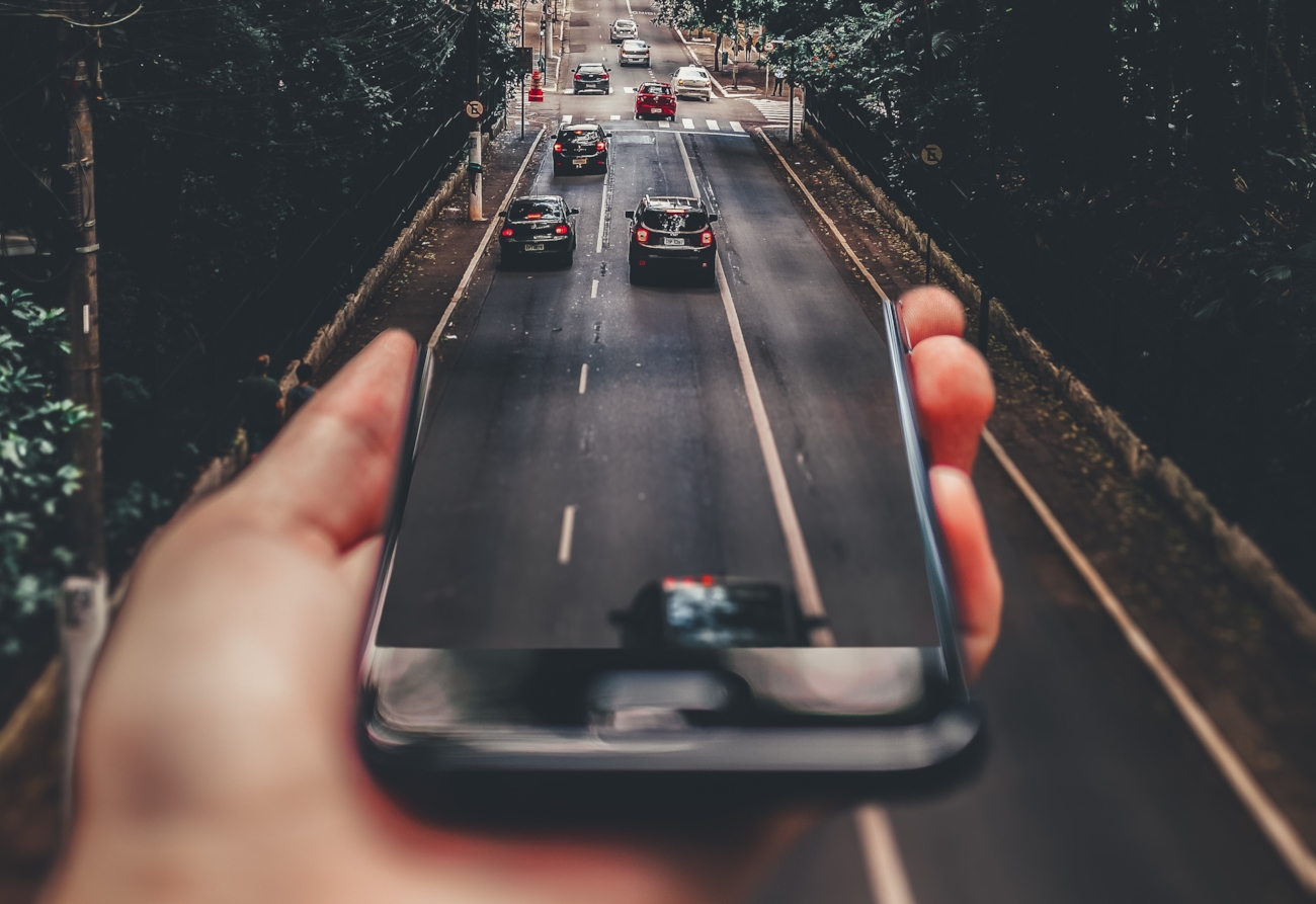 Illustrasjon av mobil som blir til en vei med biler på